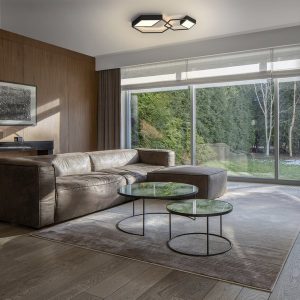 Elegant living room with garden view from window wall, wooden floor and wall and big corner sofa