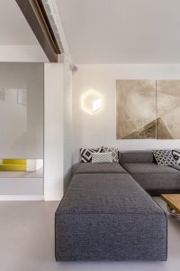 Grey corner sofa in modern open room in scandi style